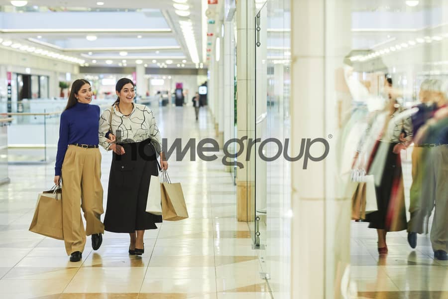 5 two-smiling-women-walking-shopping-mall. jpg