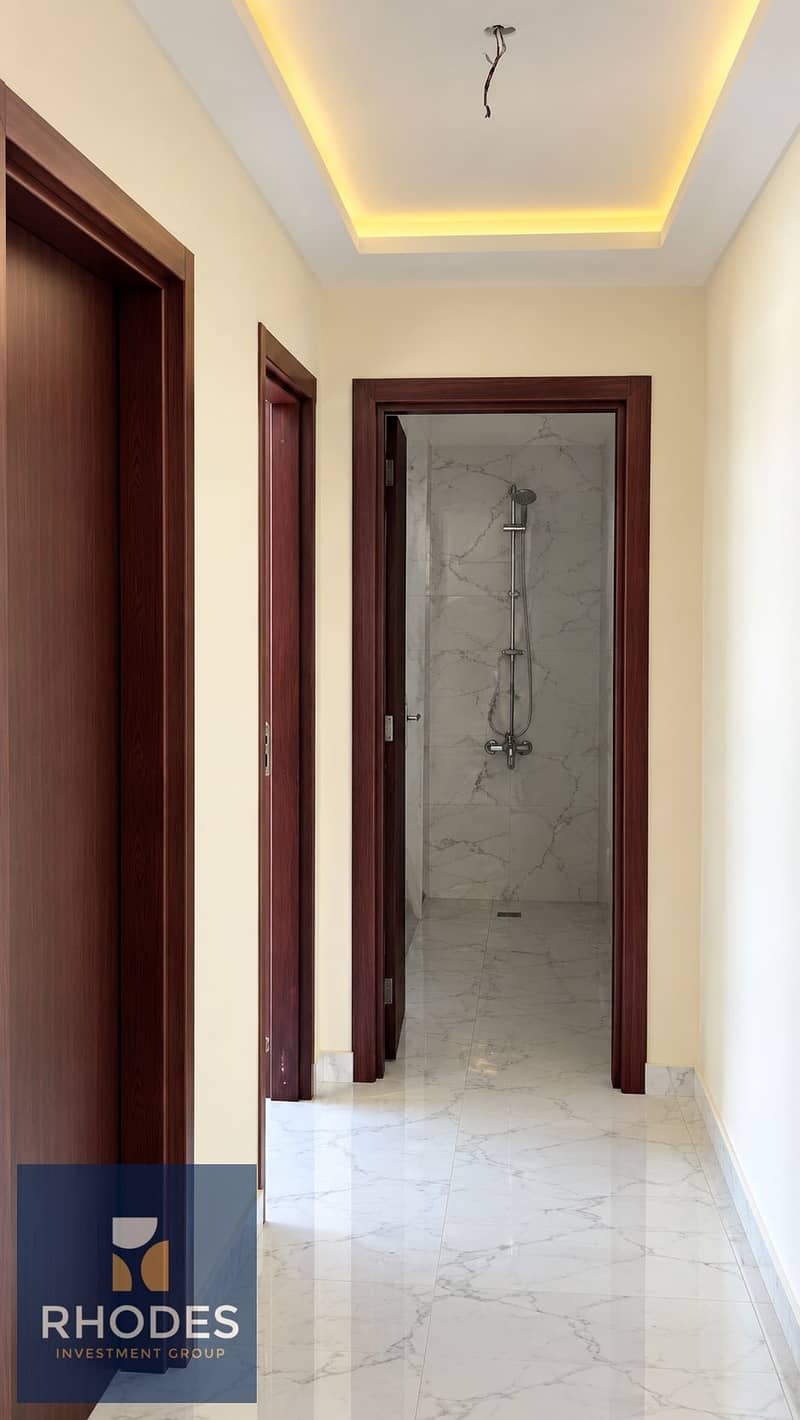 6 Warm-Lit Marble Hallway to Shower. png